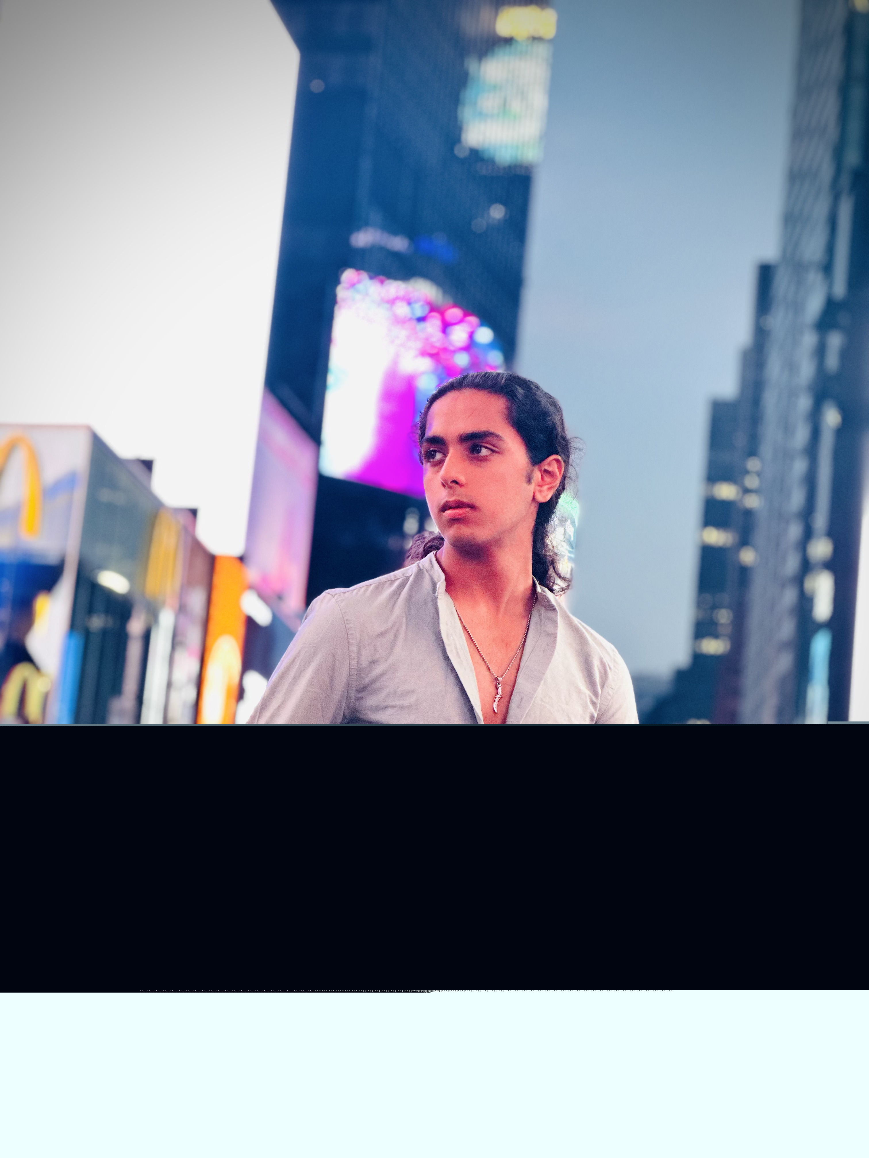 Aryan Rohira amid the bright lights of Times Square at night